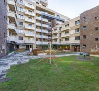 A lakókomplex udvara játszótérrel a Na križovatkách utcában, Pozsony - Ružinov.