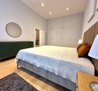 Hálószoba egy kétszobás lakásban ággyal, szekrényekkel és fa dekorációjú padlóval.