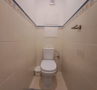 WC csempével és kék-sárga burkolattal egy háromszobás lakásban.