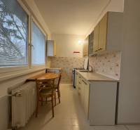 A háromszobás lakás konyhája egyszerű berendezéssel és kilátással rendelkező ablakokkal.