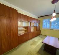 Nappali szoba fa bútorokkal és szőnyeggel egy háromszobás lakásban.