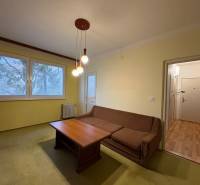 Nappali egy háromszobás lakásban kanapéval és asztallal.