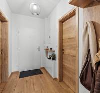 Folyosó egy kétszobás lakásban fa dekorációjú padlóval és fa ajtókkal.