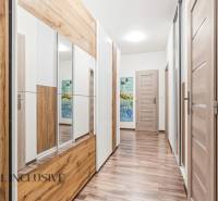 Előszoba egy kétszobás lakásban, fa dekor padlóval és tükrös szekrénnyel.