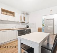 Konyha egy kétszobás lakásban világos szekrényekkel és fa dekorációjú padlóval.