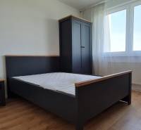 Hálószoba ággyal, szekrénnyel és fa dekoros padlóval egy kétszobás lakásban.