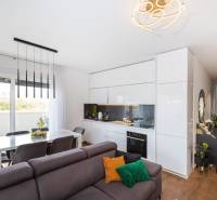 Nappali és konyha a nyaraló apartmanban fa hatású padlóval és étkező sarokkal.