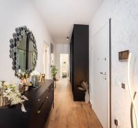 Folyosó fa dekorációjú padlóval és stílusos tükörrel egy üdülő apartmanban.