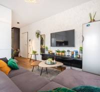 Stílusos nyaraló apartman belső tér kanapéval, asztallal és fa dekorációjú padlóval.