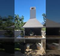 A Ninski Zatonban található nyaraló apartman külseje grillezővel és zöld növényzettel a teraszon.