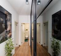 Folyosó egy üdülő apartmanban fa dekor padlóval, képekkel és tükrökkel.