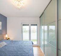 Hálószoba a nyaraló apartmanban fa dekoros padlóval és nagy gardróbbal.