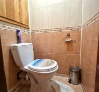 Fürdőszoba egy kétszobás lakásban kerámia burkolatokkal és WC-vel.