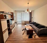 Nappali egy kétszobás lakásban fa dekorációjú padlóval és kanapéval.