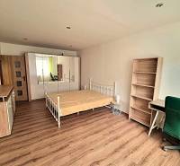 Hálószoba egy kétszobás lakásban ággyal, szekrénnyel és fa dekorációjú padlóval.