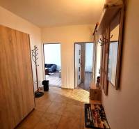 Folyosó egy 2 szobás lakásban fogassal és fa mintázatú padlóval.