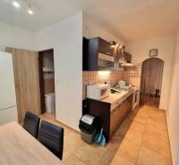 Konyha egy kétszobás lakásban csempével, fa dekorációval és berendezéssel.