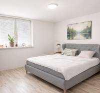 Világos hálószoba családi házban, franciaággyal és fa dekoros padlóval.