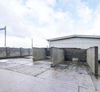 A fényképen a Šenkvice-i Nádražná utcában található raktárak és csarnokok láthatók, szilárd betonfalakkal.