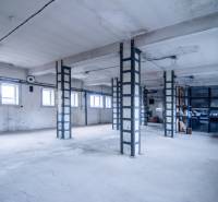 Oszlopokkal és ablakokkal rendelkező helyiségek, amelyeket raktárként és csarnokként használnak.