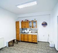 A raktár belső terében konyhapult, dekorációk és csempézett padló található.