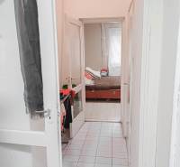 Keskeny fehér folyosó vezet a gyerekszobába egy családi házban.