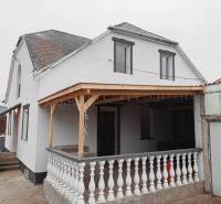 Vizsolyi családi ház terasszal, fehér homlokzattal és fa előtetővel.