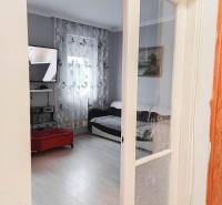 Nappali egy családi házban, televízióval és fa dekorációjú padlóval.