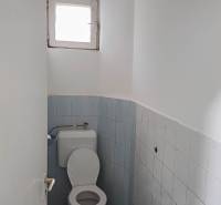 WC egy családi házban kék csempékkel és kis ablakkal.