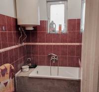 Fürdőszoba családi házban zuhanyzóval, káddal, ablakkal és bojlerrel.