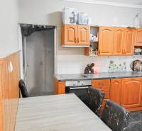 Konyha családi házban fa szekrényekkel és mennyezeti burkolattal.