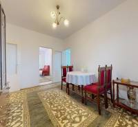 Ebédlő egy 4 szobás lakásban szőnyegekkel és díszes bútorokkal.