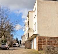 A Hviezdoslavova utcai lakóház Michalovcén, fákkal és parkoló autókkal körülvéve.