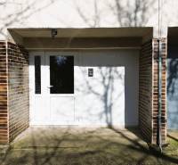 Bejárat a négy szobás lakásba a Hviezdoslav utcán, Michalovcén, téglafalú homlokzattal.