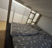 Hálószoba egy kétszobás lakásban fa dekor padlóval és emeletes ággyal.