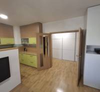 2 szobás lakás belső tere fa mintázatú padlóval és világos bútorokkal.