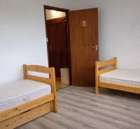 Gyerekszoba szabványos ágyakkal és fa dekor padlóval egy háromszobás lakásban.