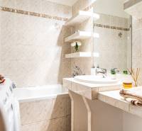 Fürdőszoba háromszobás lakásban, zuhanyzóval, mosdóval és mosógéppel.