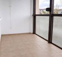 Üvegezett erkély egy 3 szobás lakásban, csempézett padlóval, kilátással a környékre.