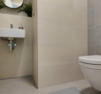 Két szobás lakás fürdőszobája függesztett WC-vel, mosdóval és fehér csempékkel.