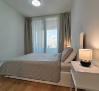 Hálószoba egy kétszobás lakásban ággyal, éjjeliszekrénnyel és fa dekorációjú padlóval.