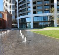 Szökőkút és modern épületek téglás építészettel Pozsonyban - Óváros, a Továrenská utcában.