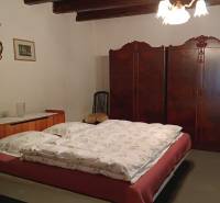 Hálószoba családi házban ággyal, beépített szekrénnyel és vidéki dekorációval.