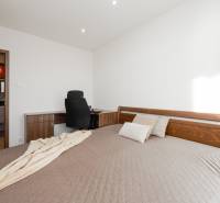 Hálószoba íróasztallal és ággyal egy 4 szobás lakásban. Kilátás a fürdőszobára.