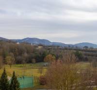 Kilátás a Pod hájom utcáról Dubnica nad Váhomban, magában foglalja a közeli parkot és dombokat.