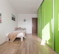 Világos hálószoba ággyal és zöld ajtós szekrénnyel egy négy szobás lakásban.