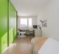 Szoba zöld szekrénnyel, íróasztallal és fa dekorációjú padlóval egy 4 szobás lakásban.