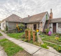 Nagyudvarnokban egy családi ház udvara gyeppel, növényekkel és épületekkel.