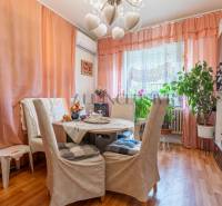 Ebédlő egy családi házban, csavarok a falon, szobanövények, fa dekorációjú padló.