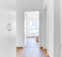 Egy 2 szobás lakás belső tere fehér falakkal és fa dekorációjú padlóval.